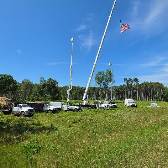 Cook's Tree Service fleet of bucket trucks and cranes with American flag